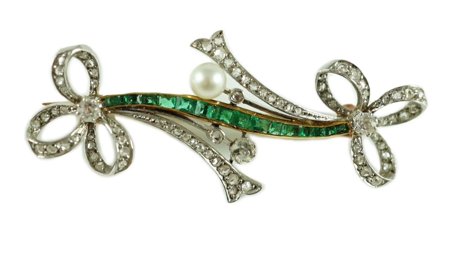 A Belle Epoque gold and platinum, emerald, diamond and seed pearl set twin ribbon bow bar brooch